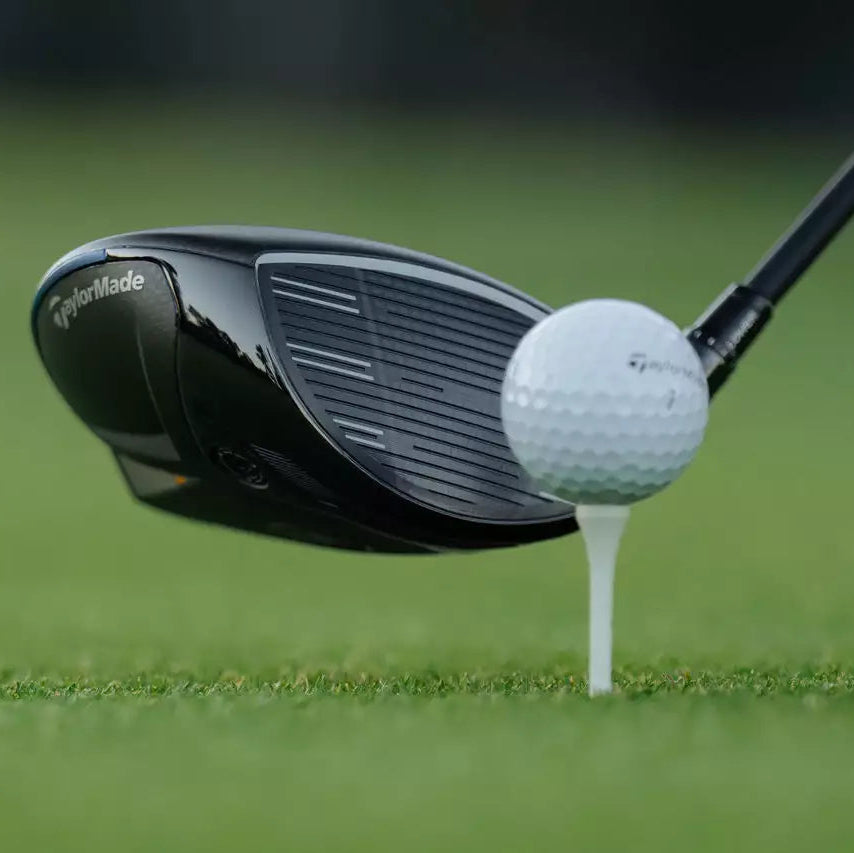 Golfeur homme au départ frappant avec un driver de golf sur un parcours
